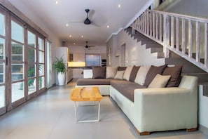 Relax in this stylish living room with a comfortable sofa, coffee table, and large windows.