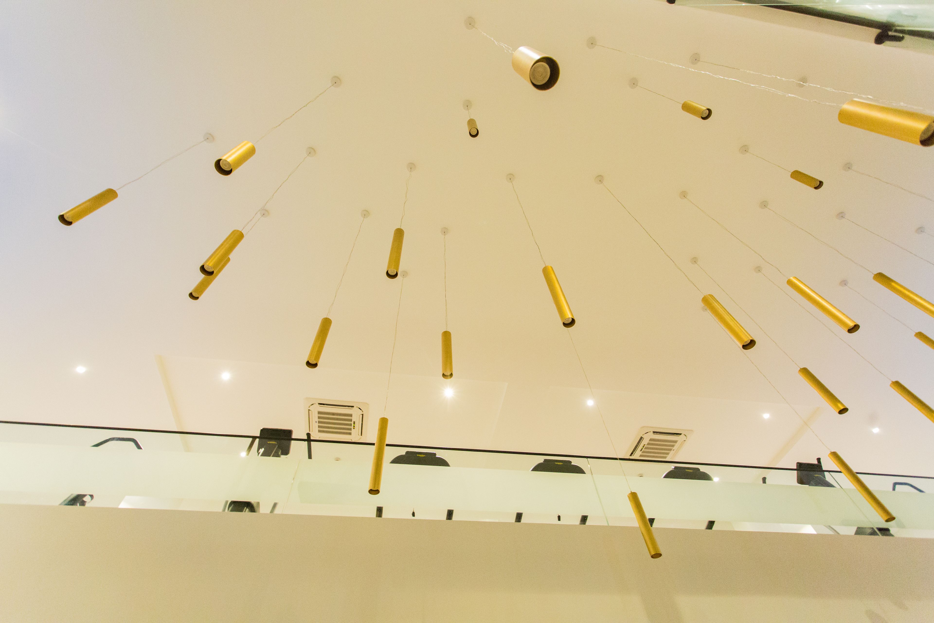 A ceiling with hanging cylindrical lights and visible air vents.