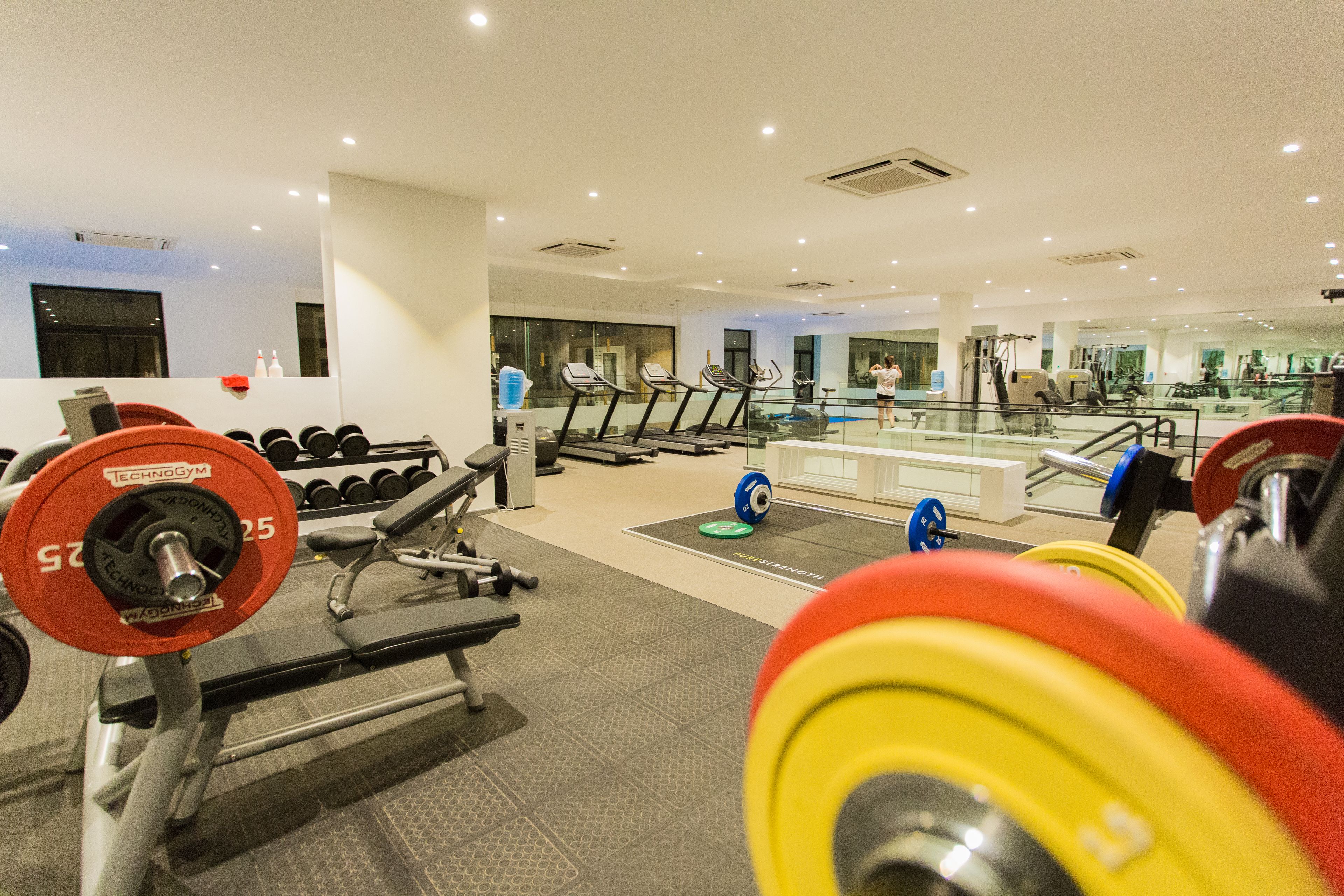 A gym with weightlifting equipment, treadmills, and exercise machines.