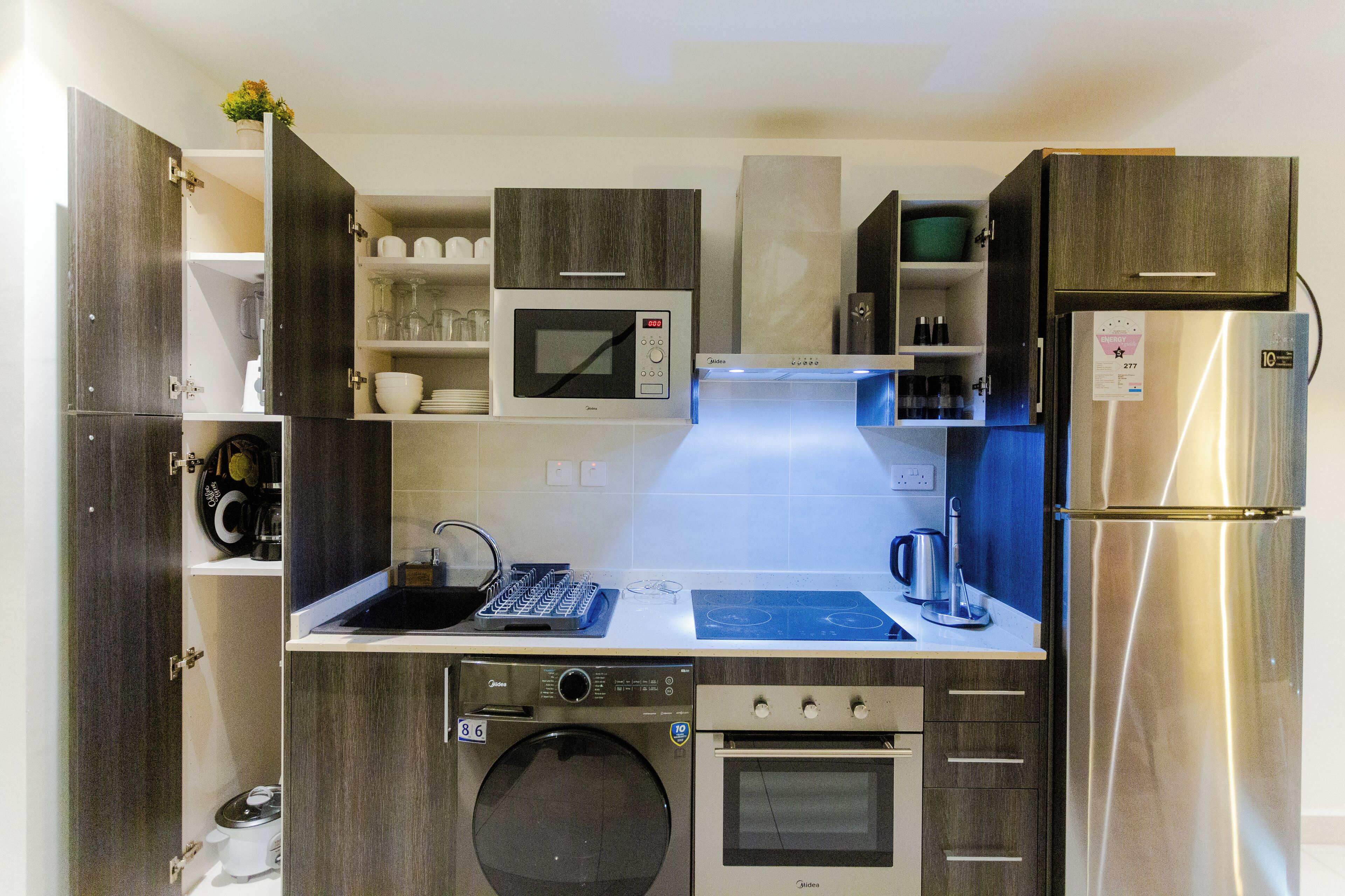 Una cocina compacta con microondas, horno y cafetera integrados.