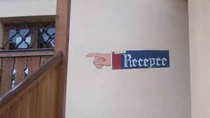 Un escalier menant à un espace d’accueil, avec un pictogramme représentant une main pointant et le mot « Accueil » inscrit sur le mur.