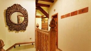 Un escalier avec des rampes en bois et un miroir décoratif accroché au mur.