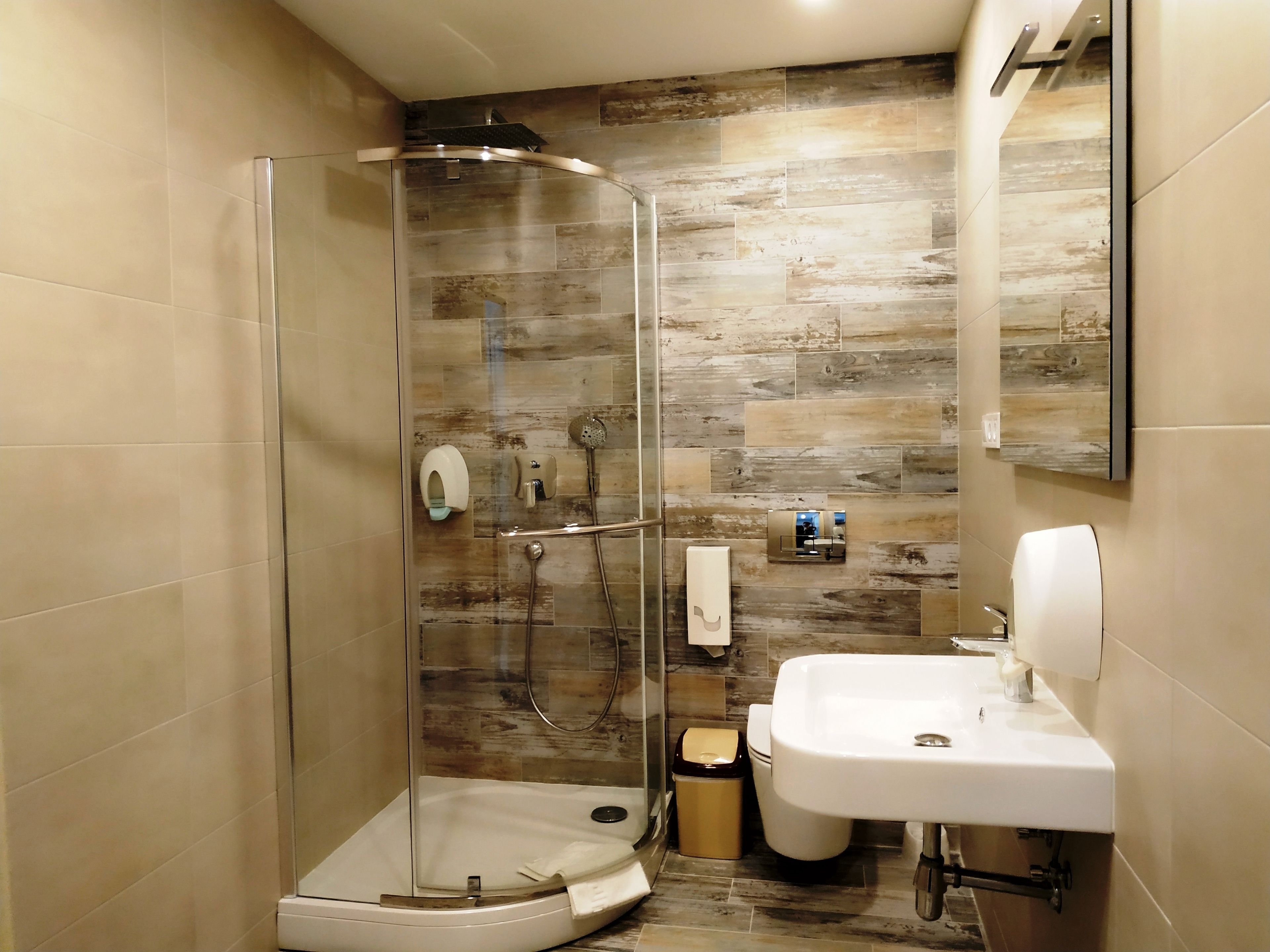 Une salle de bain moderne avec une douche à parois de verre, un lavabo et des toilettes.