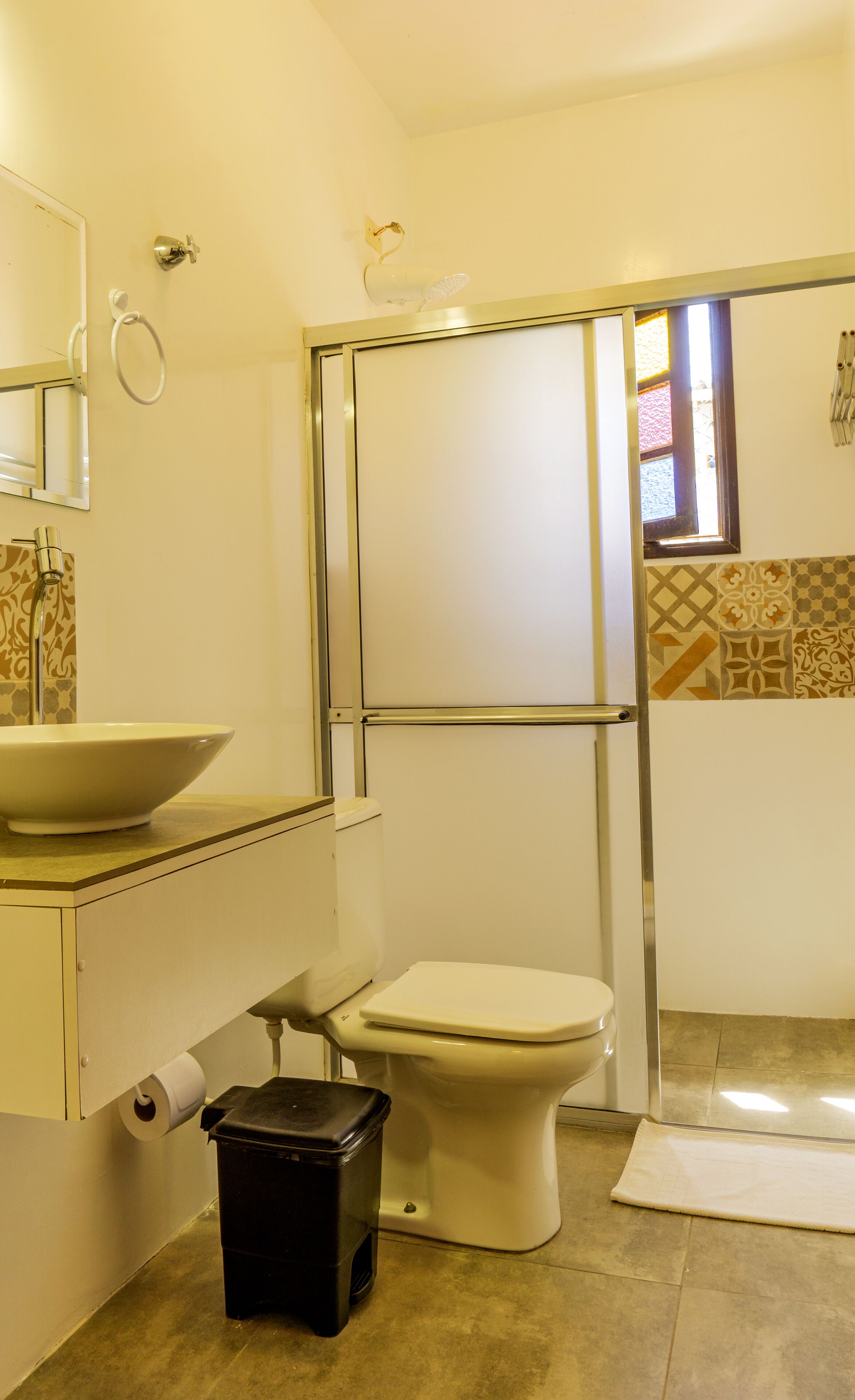 A bathroom with a toilet, sink, and shower.