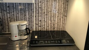 Una cocina con estufa y cafetera.