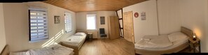 Une chambre avec deux lits, un bureau et une chaise.