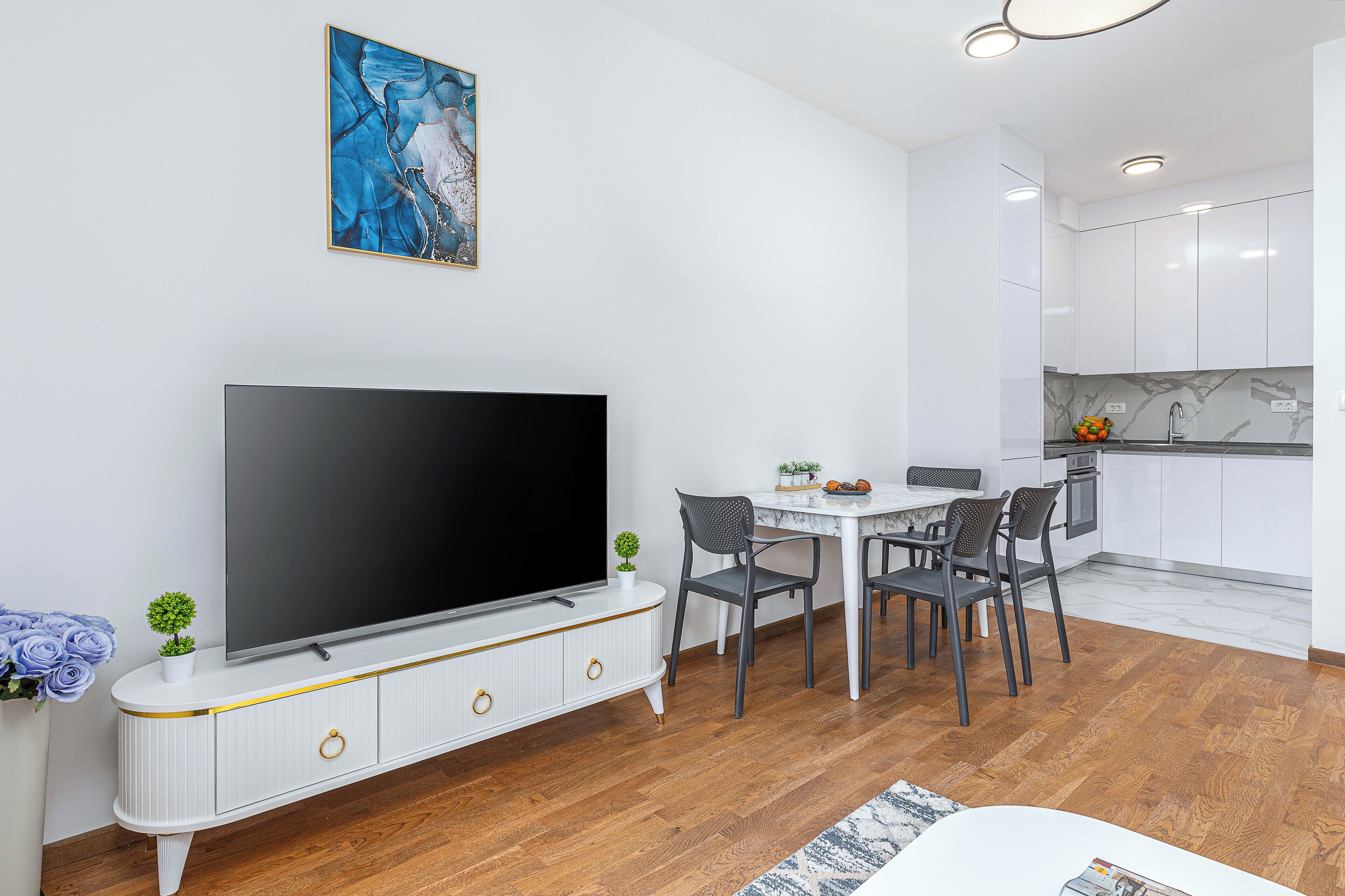 Un salon moderne doté d’un téléviseur à écran plat, d’une table à manger et de chaises.