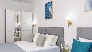 Un dormitorio moderno con una cama grande, un armario y un espejo.