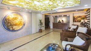 A hotel lobby with a reception desk, seating area, and a decorative ceiling. - Bodrum Moonlight Hotel (Bodrum)