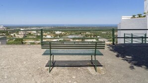 Un banc sur une terrasse en toit-terrasse, d’où l’on a une vue sur le paysage urbain.