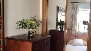 A wooden dresser with drawers, a mirror, and a vase with flowers. - Beautiful apartment facing the sea with huge terrace (El Campello)