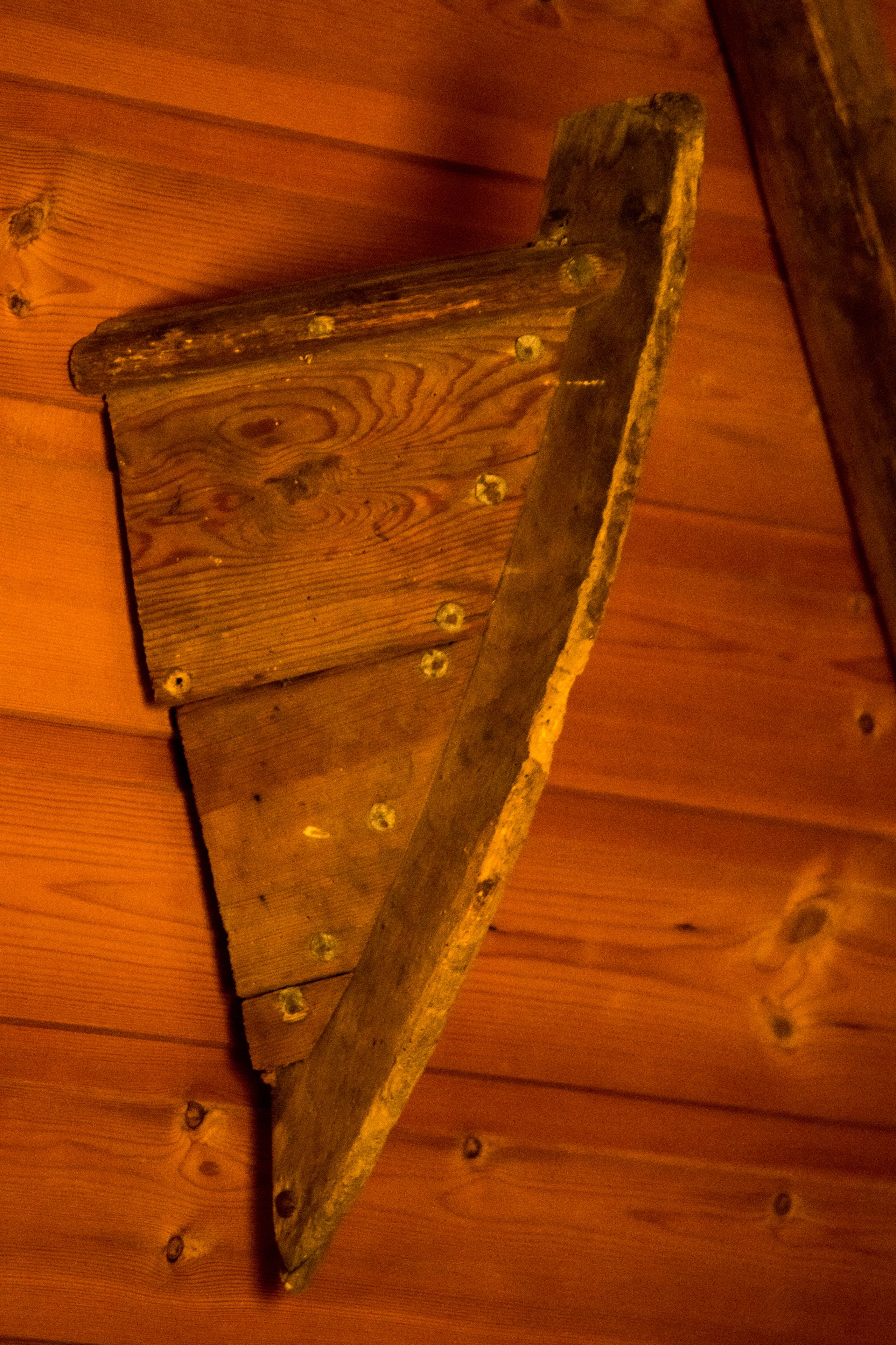 A wooden structure with a triangular shape and visible screws.