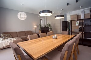 A modern living room with a wooden dining table, comfortable seating, and pendant lighting. - VILLA FILIP heated pool, sauna, 5 ensuite bedrooms, 30m from sea, (Kaštel Štafilić)
