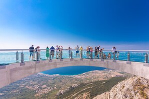 A glass bridge with a clear view of a body of water and surrounding landscape. - VILLA FILIP heated pool, sauna, 5 ensuite bedrooms, 30m from sea, (Kaštel Štafilić)