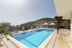 Utomhuspool, parasoller och solstolar