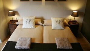 A double bed with two pillows, each with a name tag, and two bedside tables with lamps. - L'Estisora de Casa l'Hereu for 8 people (Baix Pallars)