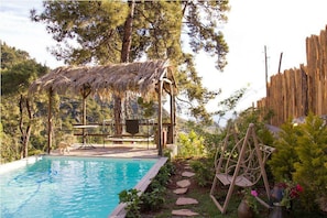 Una piscina al aire libre, sombrillas, tumbonas