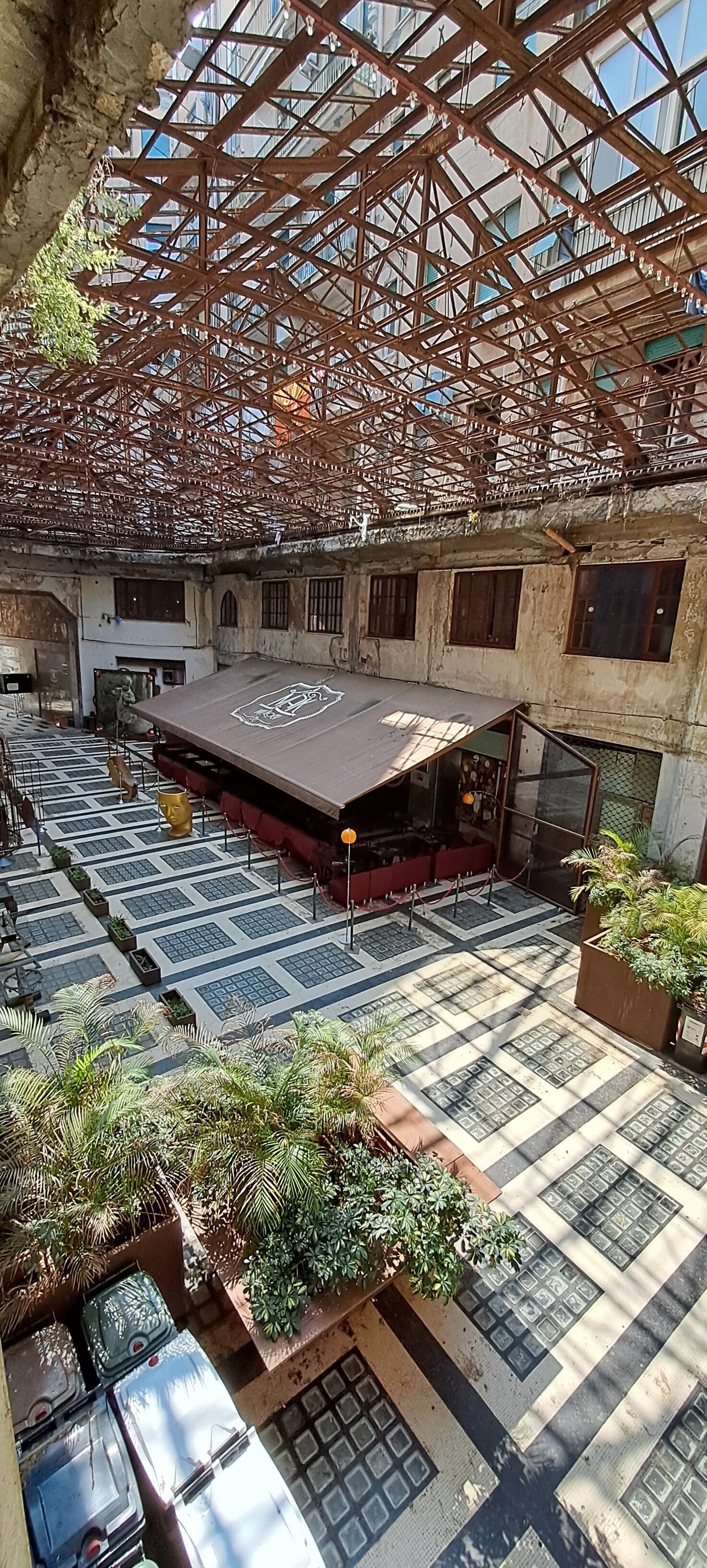 An indoor courtyard with a stage, seating, and potted plants.