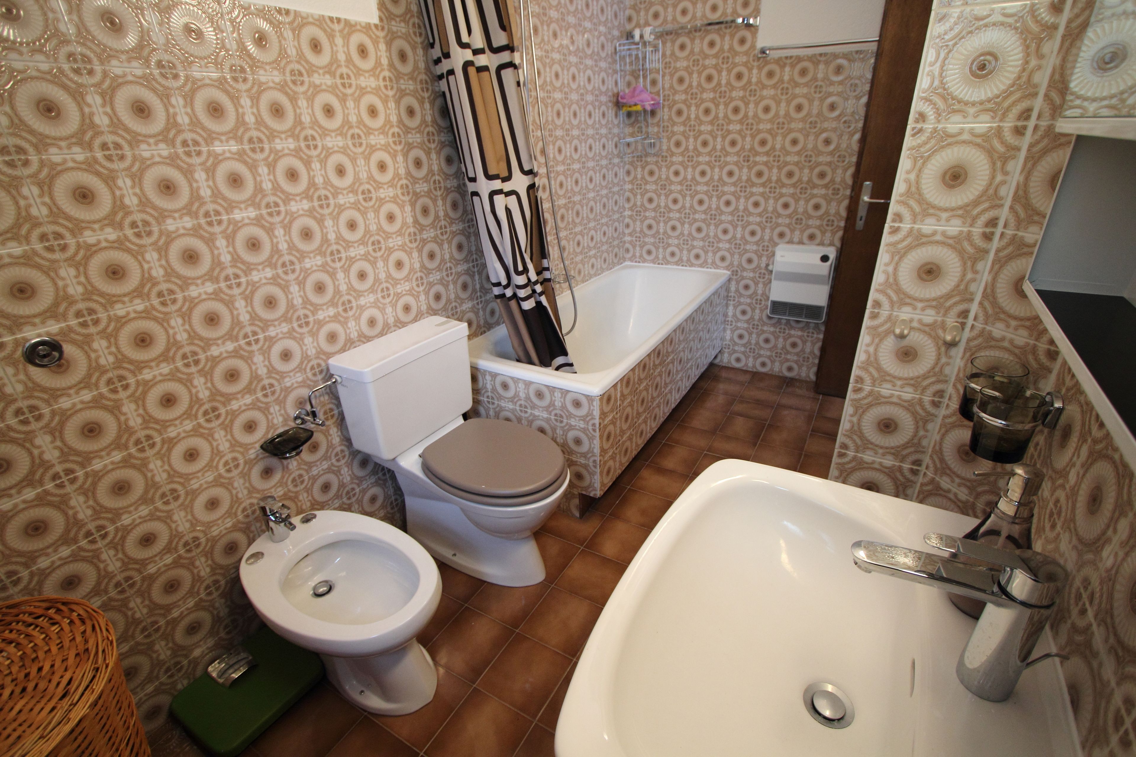 A bathroom with a toilet, bidet, bathtub, and sink.