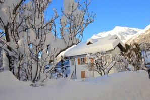 A snow-covered house with a mountain in the background. - Chalet Cuore delle Alpi (Airolo)