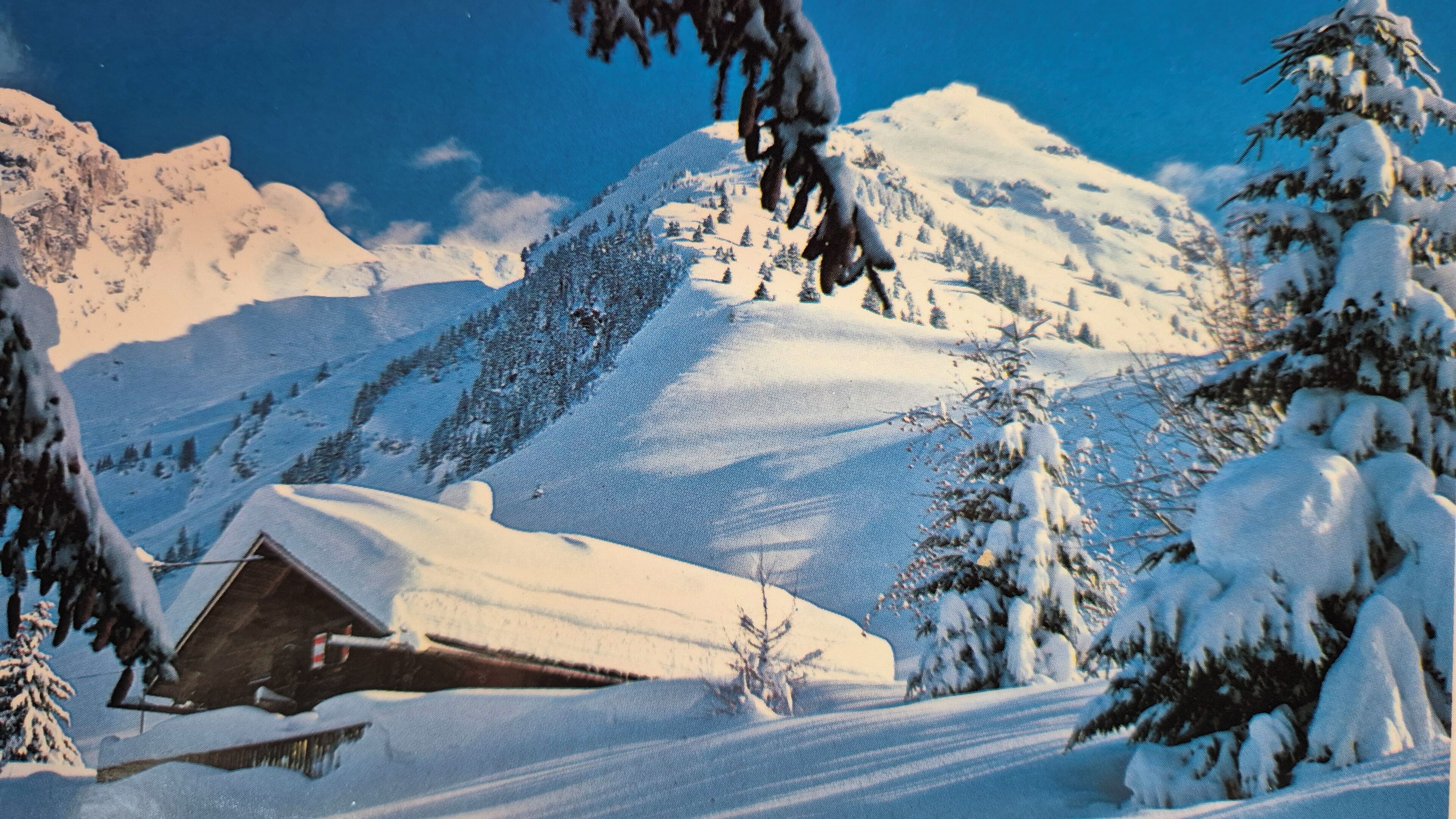 A snow-covered mountain landscape with a cabin.