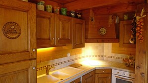 Eine Holz-Küche mit Spüle, Herd und Schränken.