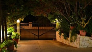 Una entrada protegida con un muro de piedra y plantas en macetas.