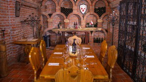 A dining area with a brick wall, wooden table, and chairs. - Casa Bohemia (Campoalegre)
