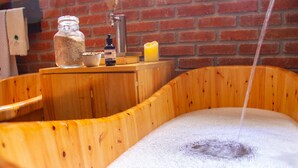 A wooden bathtub with a faucet and a bottle of soap. - Casa Bohemia (Campoalegre)
