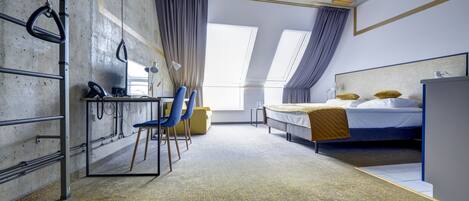 Una habitación con una cama, un escritorio y una silla. Hay cortinas en las ventanas.