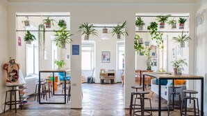 Una habitación amplia con suelo de parqué de madera, una zona de comedor con taburetes y un sofá con cojines.