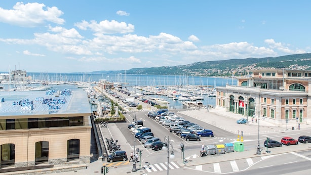 Marina con barcos, zona de estacionamiento y un edificio con cartel.