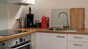 A compact kitchen with a built-in oven, a coffee maker, and a red juicer on the countertop. - Nice house with great garden in Cap Ferret, center + bay + ocean on foot (Lège-Cap-Ferret)