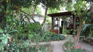 A garden pathway leading to a covered structure with a glass door. - Hostal Vida 2000 (Santa Cruz)