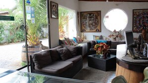 A cozy interior with a sofa, a round table, and a large window. - Hostal Vida 2000 (Santa Cruz)