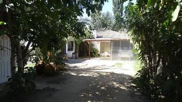 Un sendero estrecho que lleva a un edificio con techo de tejas y un porche cubierto.