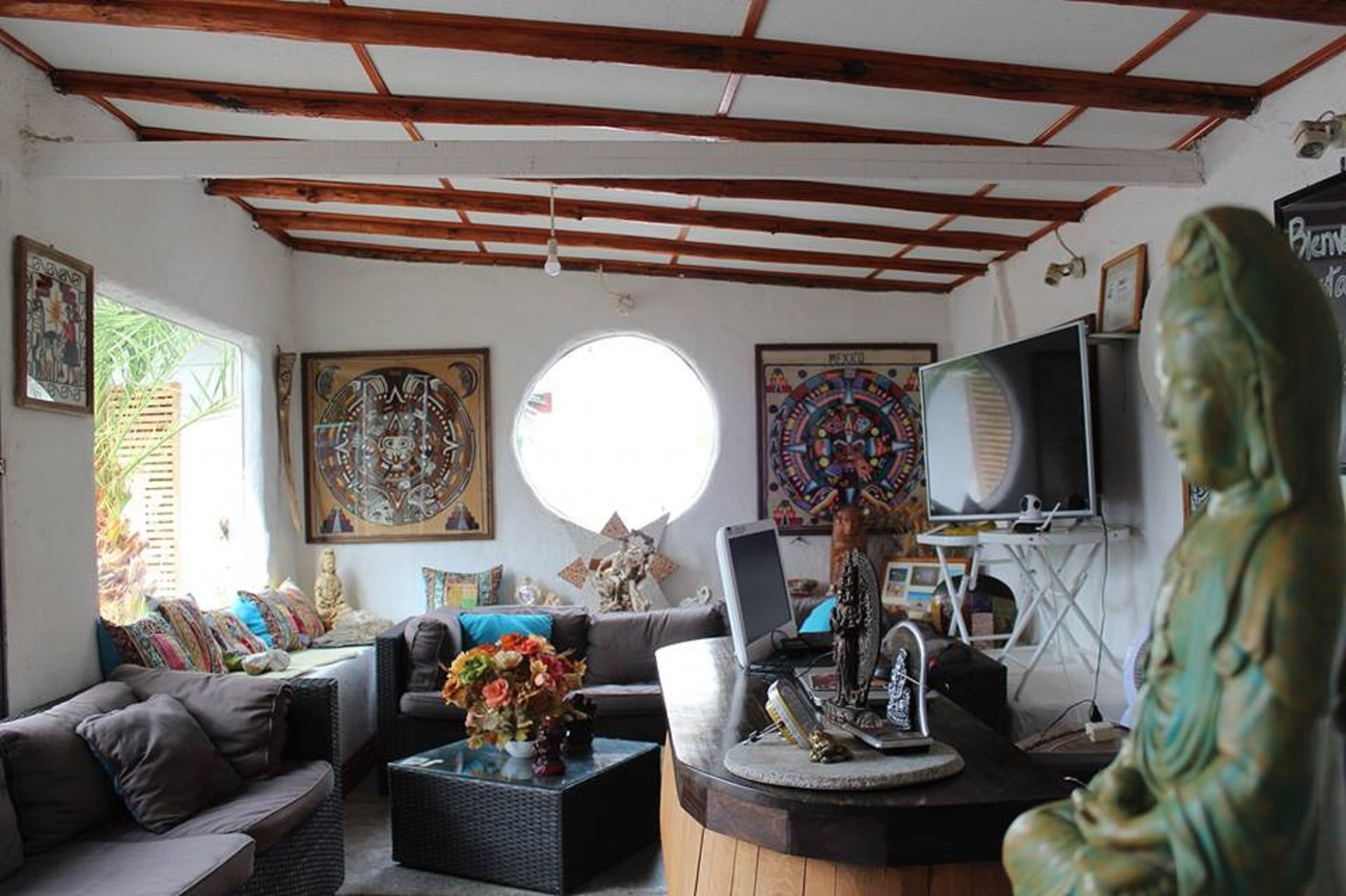 Una sala de estar con sofá, mesa de centro y obras de arte en las paredes.