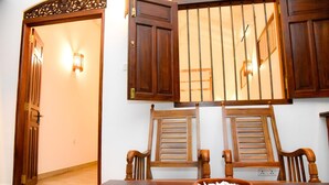 Un comedor con una mesa de madera, dos sillas, un cuenco de arroz y una vela encendida.