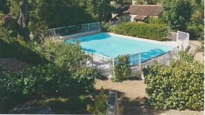 A rectangular swimming pool surrounded by a white fence, with lush greenery and trees in the background. - studio 2/3 people with porto vecchio pool (Porto-Vecchio)