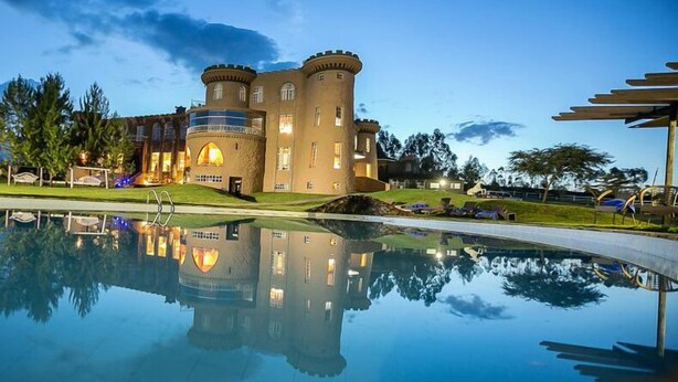 A castle-like hotel with a large pool reflecting its architecture. - Tafaria Castle (Ndaragwa)