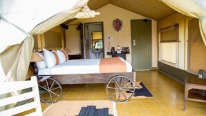 A tented room with a bed, a sink, and a small table with a kettle. - Tafaria Castle (Ndaragwa)
