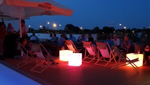 A deck area with outdoor seating and a large umbrella providing shade. - Arche Hotel Lublin (Lublin)
