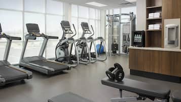 A gym with treadmills, elliptical machines, and weightlifting equipment.
