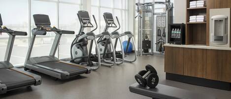 A gym with treadmills, elliptical machines, and weightlifting equipment.