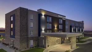 Un hôtel moderne avec une façade en pierre, de nombreuses fenêtres et une entrée abritée.