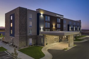 A modern hotel with a stone facade, multiple windows, and a covered entrance.