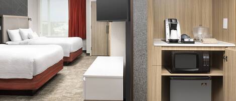A hotel room with two beds, a TV, a coffee maker, a microwave, and a refrigerator.