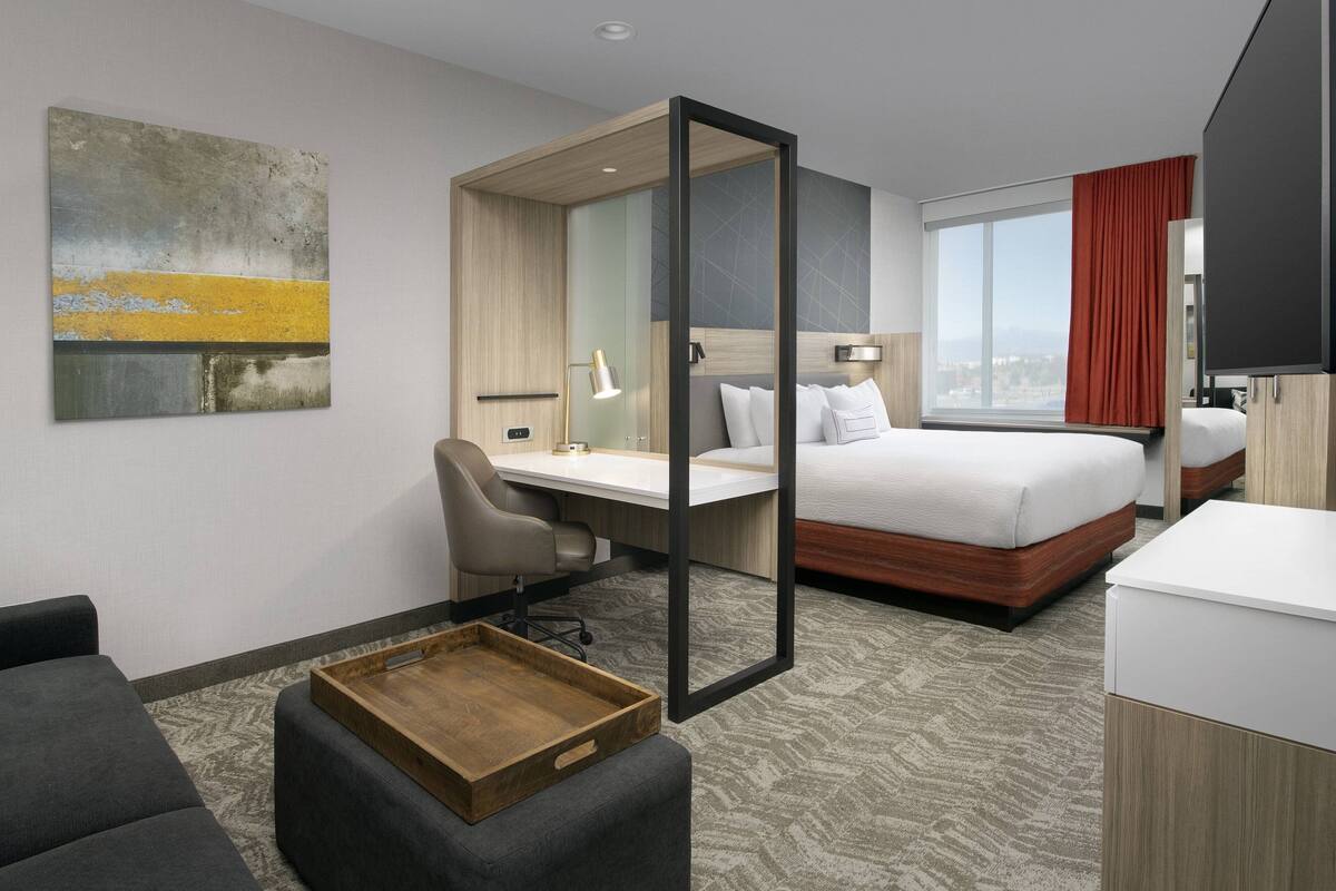 Una habitación de hotel moderna con cama, escritorio y zona de estar.