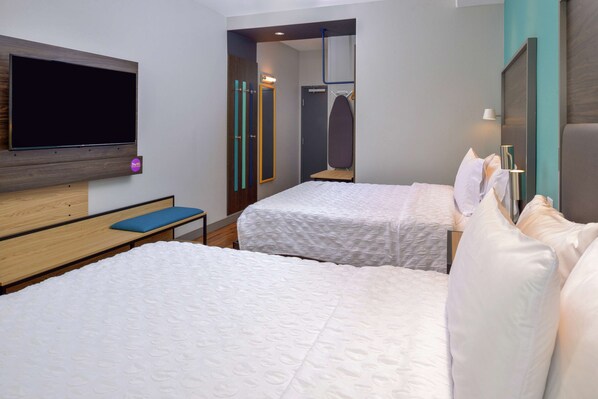 A hotel room with two beds, a TV, a mirror, and a wardrobe. - Tru by Hilton Coppell DFW Airport North (Coppell)