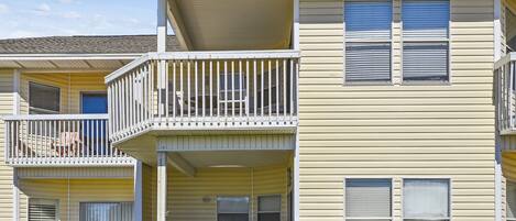 A multi-story residential building with balconies, large windows, and a flat roof.
